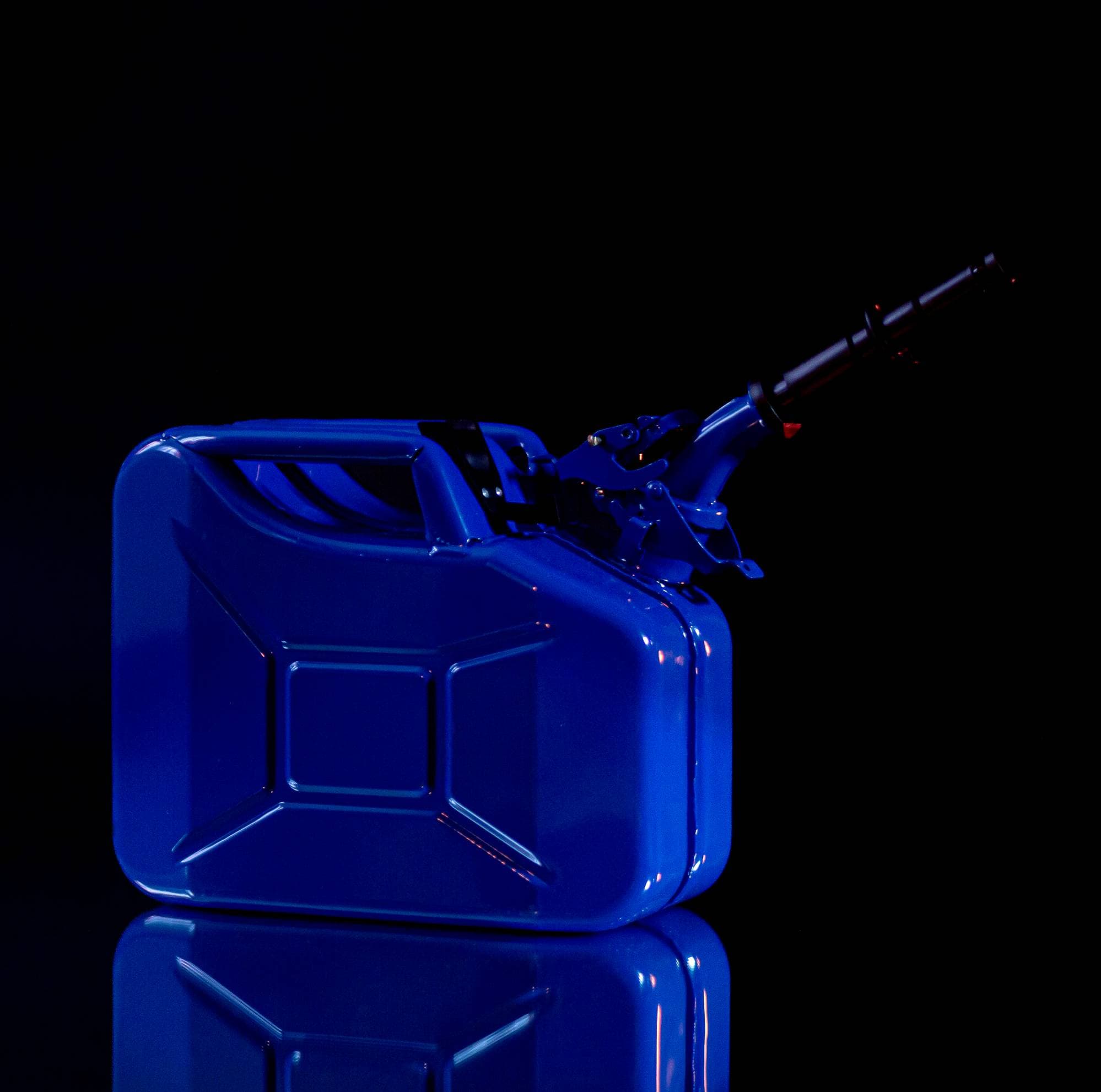 Cobalt-blue squat gasoline can with a long black spout and mirrored reflection against darkness.
